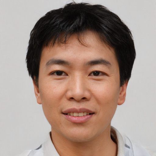 Joyful asian young-adult male with short  black hair and brown eyes