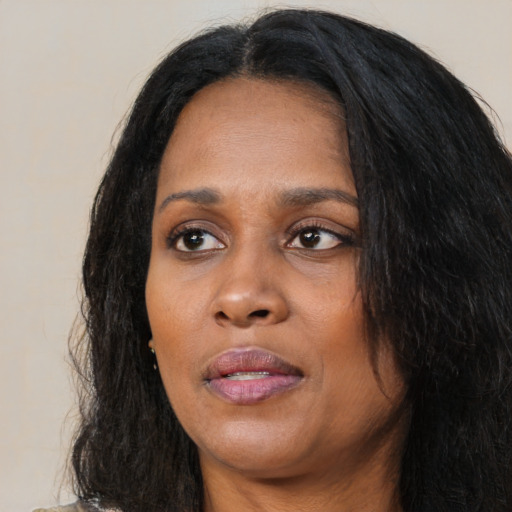 Joyful black young-adult female with long  black hair and brown eyes