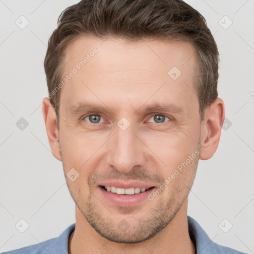 Joyful white young-adult male with short  brown hair and grey eyes