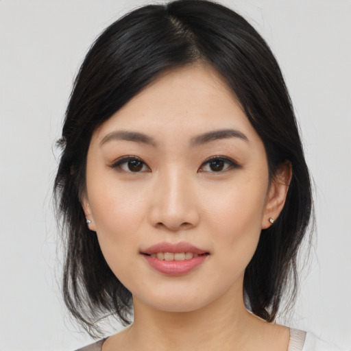 Joyful asian young-adult female with medium  black hair and brown eyes