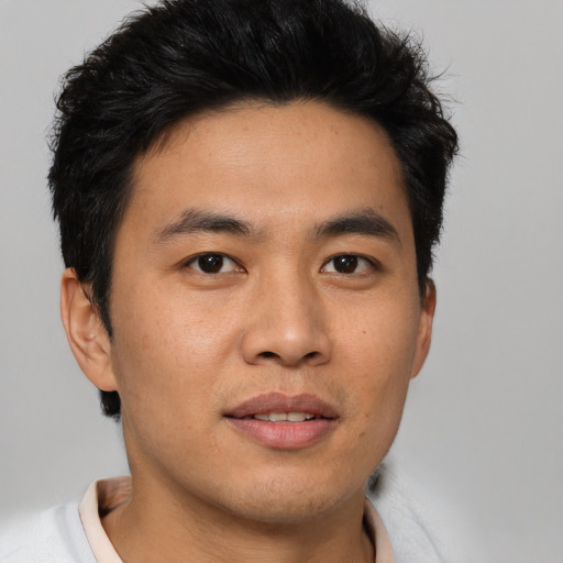 Joyful asian young-adult male with short  black hair and brown eyes