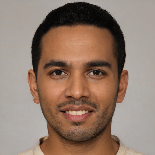 Joyful latino young-adult male with short  black hair and brown eyes