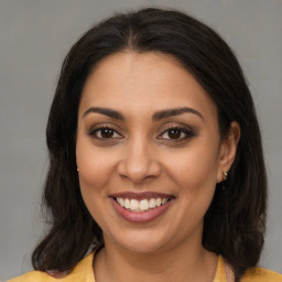 Joyful latino young-adult female with medium  brown hair and brown eyes