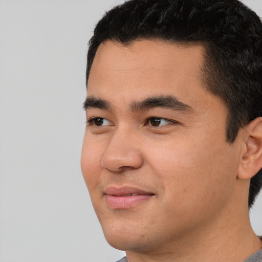 Joyful asian young-adult male with short  black hair and brown eyes