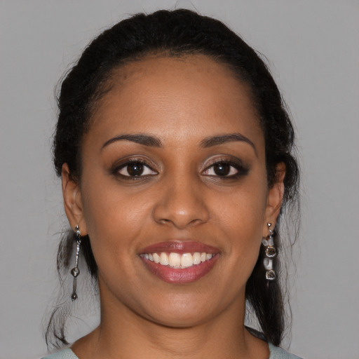 Joyful black young-adult female with long  brown hair and brown eyes