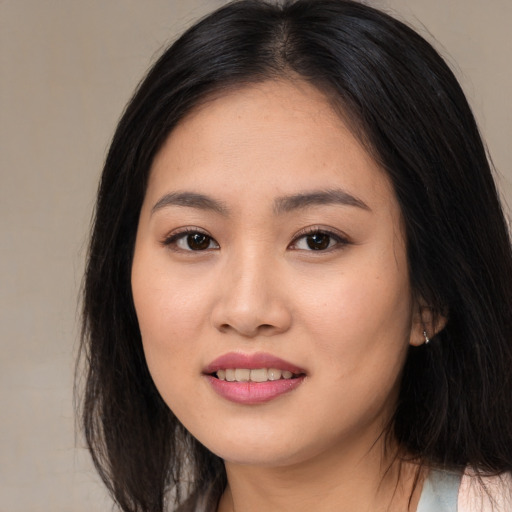 Joyful asian young-adult female with long  black hair and brown eyes