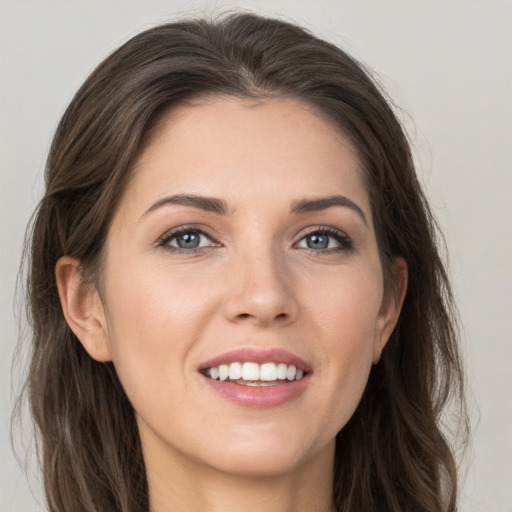 Joyful white young-adult female with long  brown hair and grey eyes