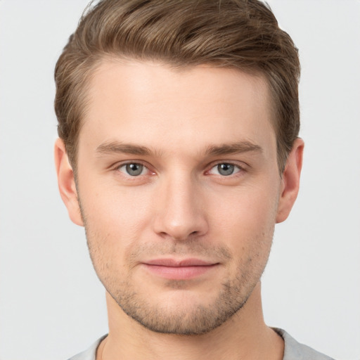 Joyful white young-adult male with short  brown hair and grey eyes