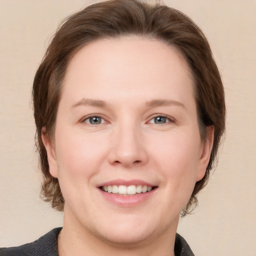 Joyful white young-adult female with medium  brown hair and grey eyes