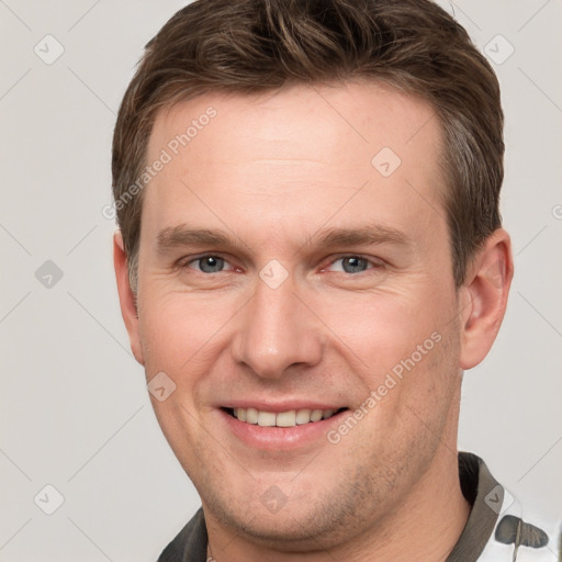 Joyful white young-adult male with short  brown hair and grey eyes