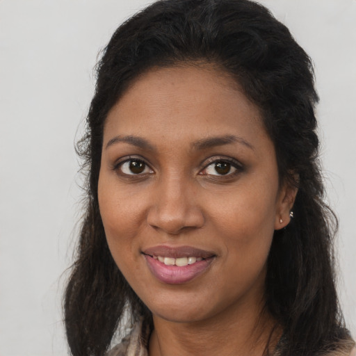 Joyful black young-adult female with long  brown hair and brown eyes