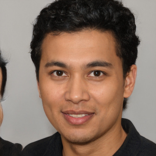 Joyful latino young-adult male with short  brown hair and brown eyes