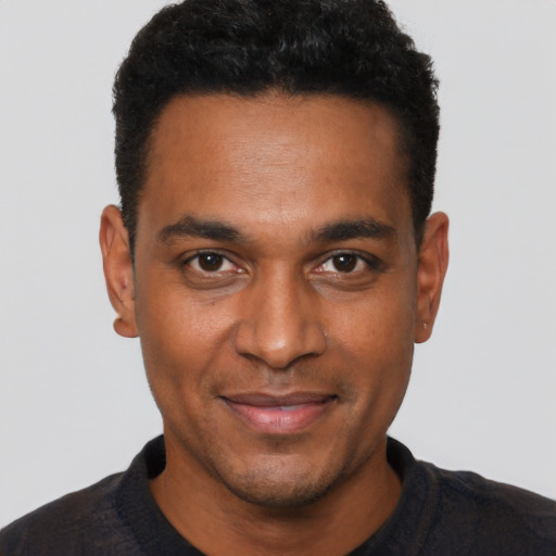 Joyful black young-adult male with short  black hair and brown eyes