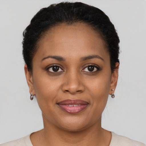 Joyful black young-adult female with short  brown hair and brown eyes