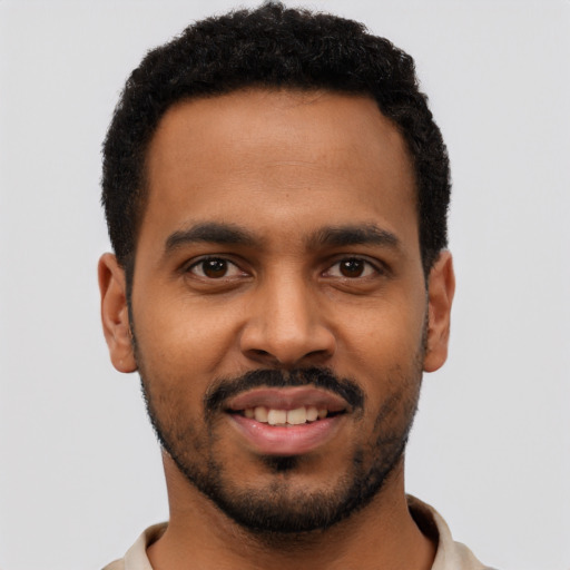 Joyful black young-adult male with short  black hair and brown eyes