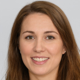 Joyful white young-adult female with long  brown hair and brown eyes