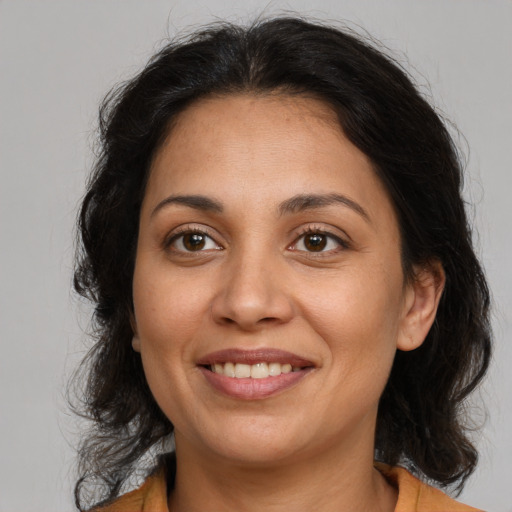 Joyful latino adult female with medium  brown hair and brown eyes