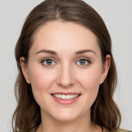 Joyful white young-adult female with medium  brown hair and grey eyes