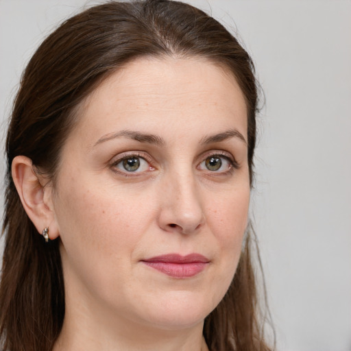 Joyful white adult female with long  brown hair and green eyes