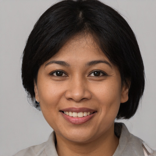 Joyful white young-adult female with medium  black hair and brown eyes