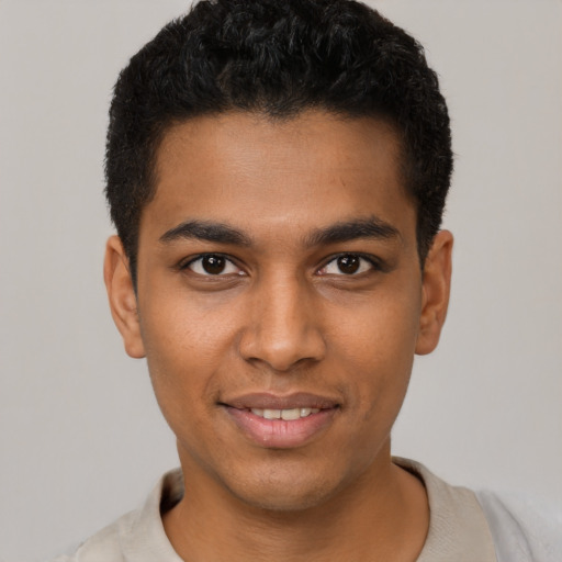 Joyful black young-adult male with short  black hair and brown eyes