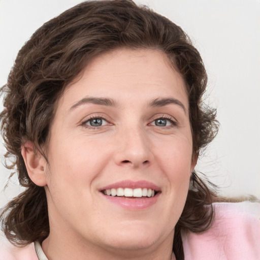 Joyful white young-adult female with medium  brown hair and green eyes