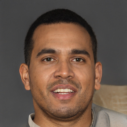 Joyful latino young-adult male with short  brown hair and brown eyes