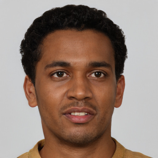 Joyful black young-adult male with short  brown hair and brown eyes
