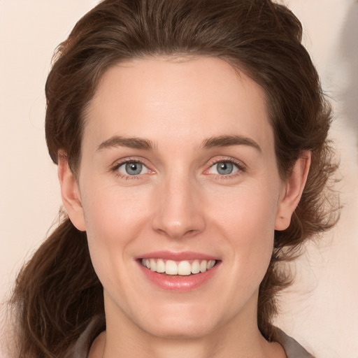 Joyful white young-adult female with medium  brown hair and green eyes