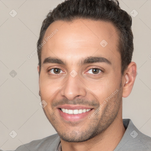 Joyful white young-adult male with short  brown hair and brown eyes