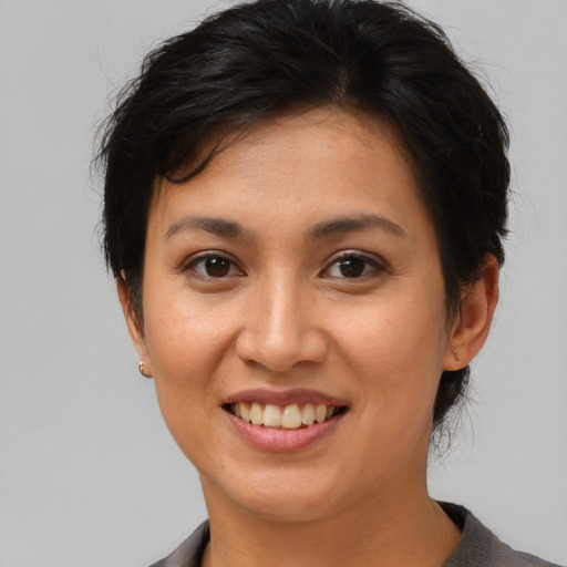 Joyful asian young-adult female with short  brown hair and brown eyes