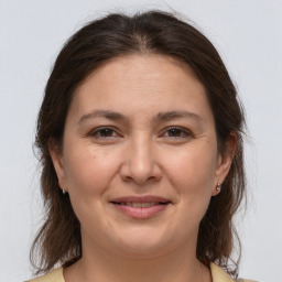 Joyful white adult female with medium  brown hair and brown eyes