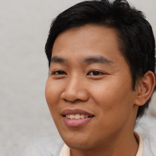 Joyful asian young-adult male with short  black hair and brown eyes