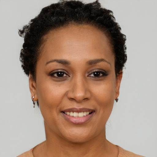 Joyful black adult female with short  black hair and brown eyes