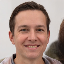 Joyful white young-adult male with short  brown hair and brown eyes