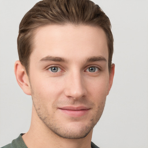 Joyful white young-adult male with short  brown hair and grey eyes