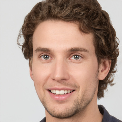 Joyful white young-adult male with short  brown hair and green eyes