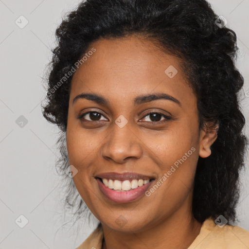 Joyful black young-adult female with long  black hair and brown eyes