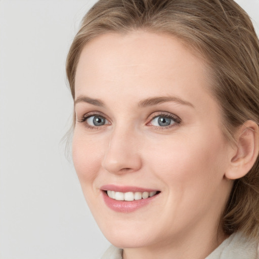 Joyful white young-adult female with long  brown hair and blue eyes