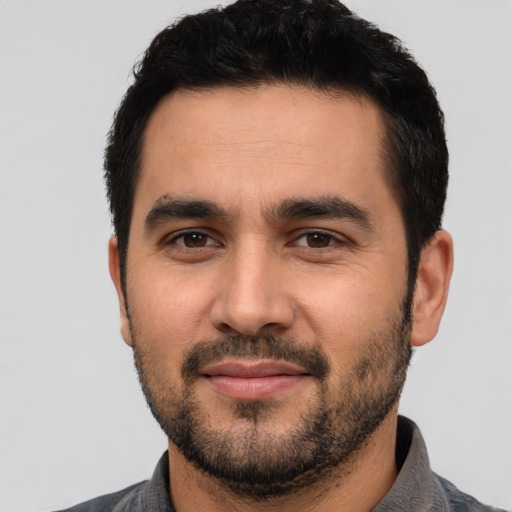 Joyful latino young-adult male with short  black hair and brown eyes