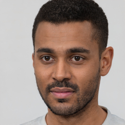 Joyful black young-adult male with short  black hair and brown eyes