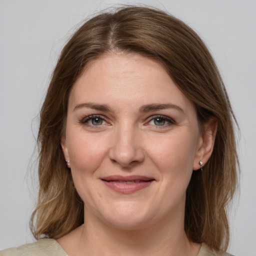 Joyful white young-adult female with medium  brown hair and grey eyes