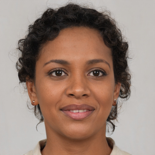 Joyful black young-adult female with short  brown hair and brown eyes
