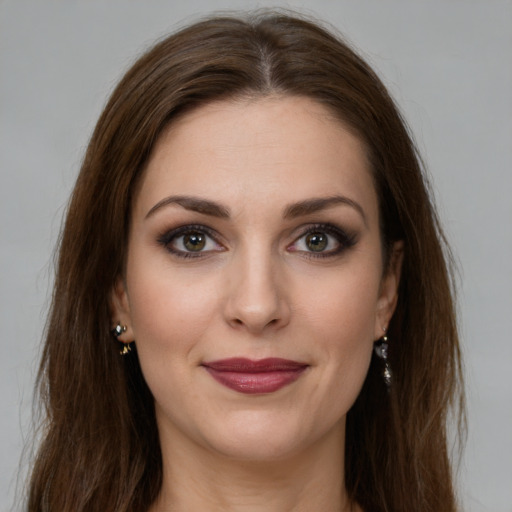 Joyful white young-adult female with long  brown hair and green eyes