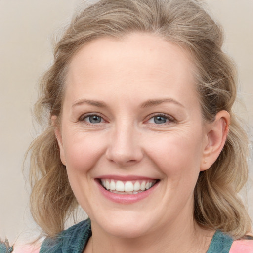 Joyful white young-adult female with medium  brown hair and blue eyes