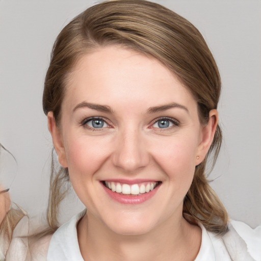 Joyful white young-adult female with medium  brown hair and blue eyes