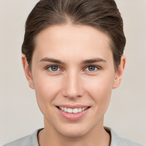 Joyful white young-adult female with short  brown hair and grey eyes