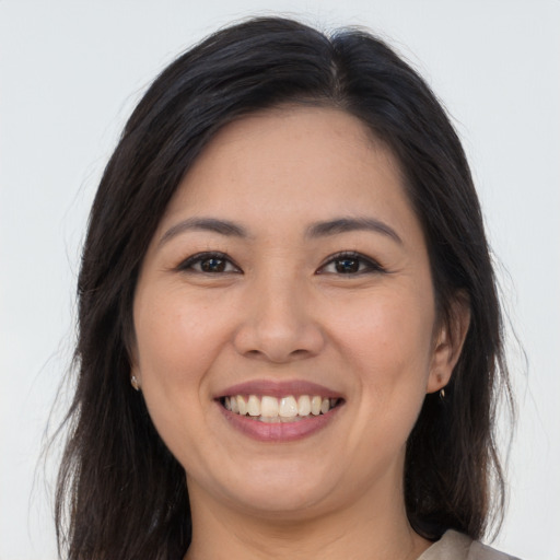 Joyful asian young-adult female with long  brown hair and brown eyes