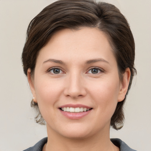 Joyful white young-adult female with medium  brown hair and grey eyes