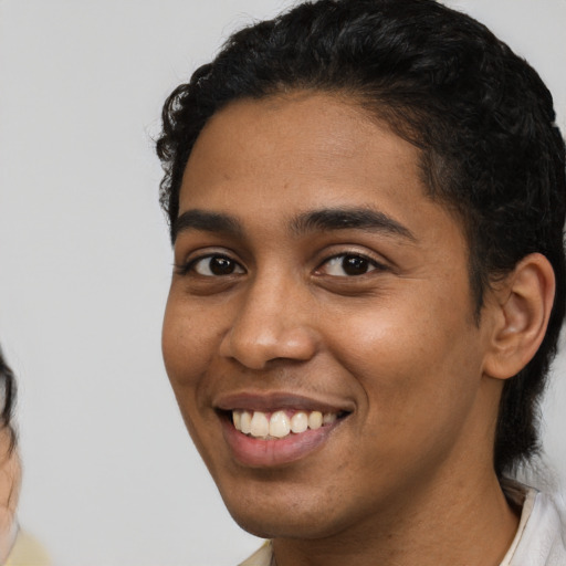 Joyful latino young-adult male with short  black hair and brown eyes